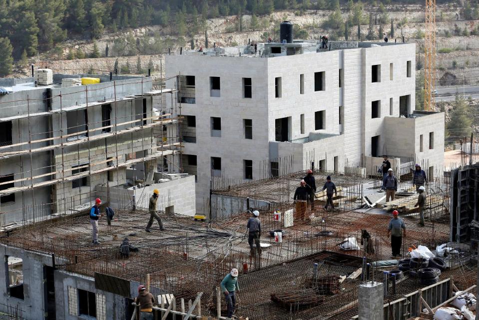 Labourers work at a construction site in the Israeli settlement of Ramot in an area of the occupied West Bank that Israel annexed to Jerusalem January 22, 2017. REUTERS/Ronen Zvulun