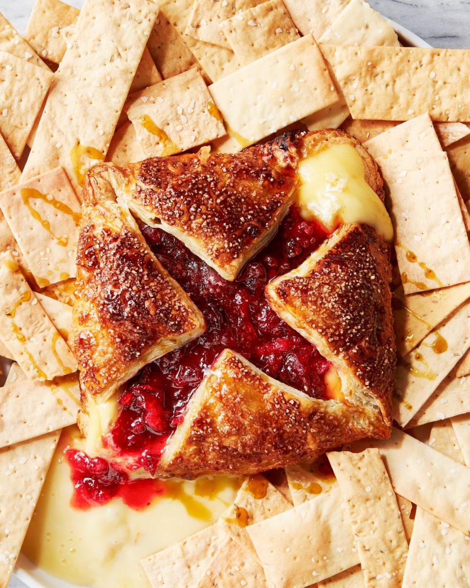 wrapped baked brie topped with cranberry and maple and served with crackers