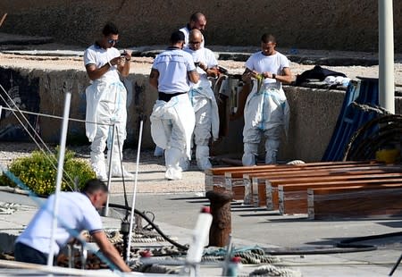 Emergency services wait to carry bodies from a migrant shipwreck that took place on October 7 back to the island of Lampedusa