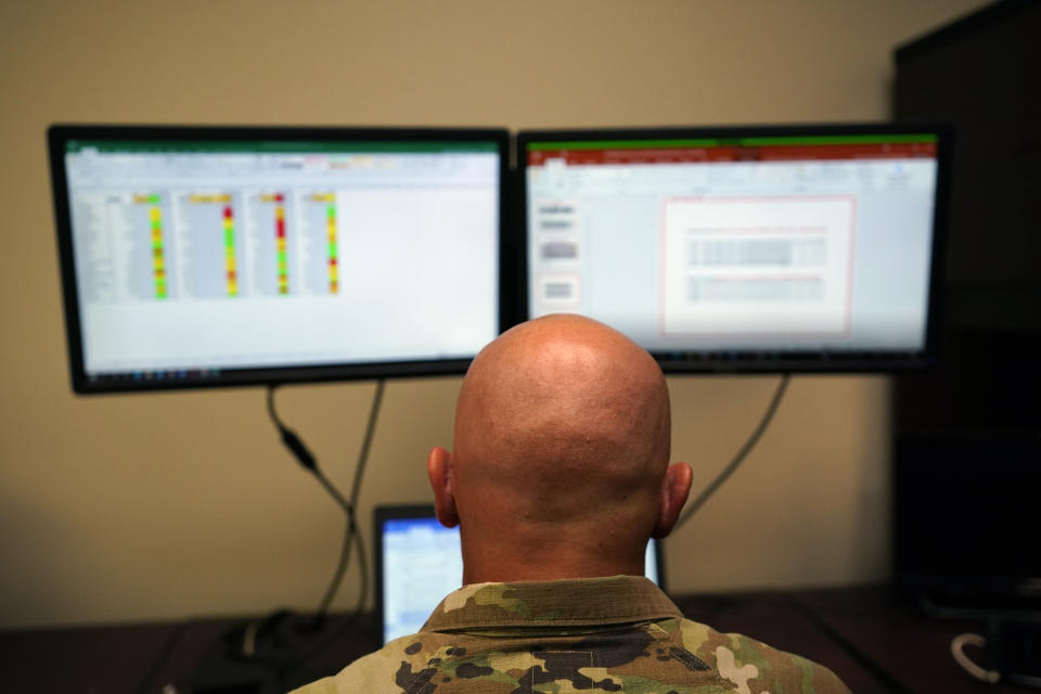 Capt. Michael Switzer sits at his desk before he goes to sleep in his office at Camp Beauregard in Pineville, La., Friday, July 30, 2021. (AP Photo/Gerald Herbert)