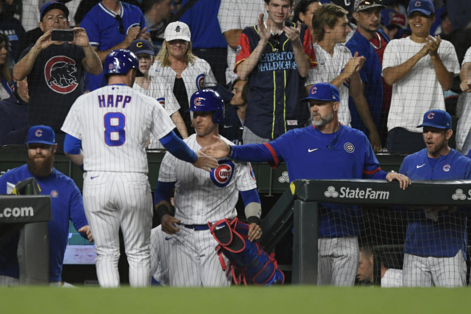 Chicago Cubs' Ian Happ (8) celebrates at the dugout with manager David Ross right, after scoring on a Mike Tauchman RBI single during the sixth inning of a baseball game against the Tampa Bay Rays Tuesday, May 30, 2023, in Chicago. (AP Photo/Paul Beaty)