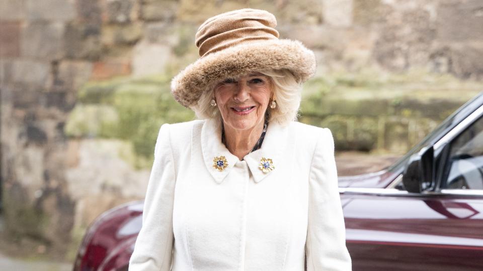 Queen Camilla wearing her Fiona Clare coat dress alongside a luxe top-handle accessory 