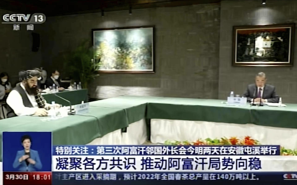 In this image taken from video footage run by China's CCTV on Wednesday, March 30, 2022, Chinese Foreign Minister Wang Yi holds talks with Taliban-appointed Afghanistan foreign minister Amir Khan Muttaqi at right during a meeting held in Tunxi district in eastern China's Anhui province. China's ambitions to have a major hand in Afghanistan's stability and development under the Taliban, while boosting its own stature, will be on display at a pair of multinational meetings it is hosting starting Wednesday. (CCTV via AP)