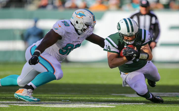 Nov 29, 2015; East Rutherford, NJ, USA; New York Jets quarterback Ryan Fitzpatrick (14) dives for a first down while Miami Dolphins defensive tackle Earl Mitchell (90) makes a tackle attempt during the first half at MetLife Stadium. Mandatory Credit: Ed Mulholland-USA TODAY Sports