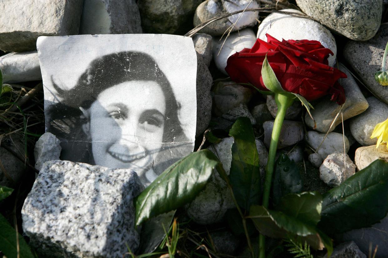 <p>A picture of Anne Frank lies in front of a memorial stone</p> (AFP/Getty)