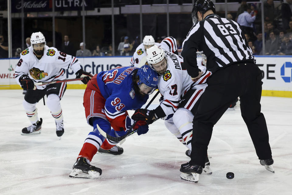 New York Rangers center Mika Zibanejad (93) and Chicago Blackhawks center Jason Dickinson (17) fight for the puck as Chicago Blackhawks left wing Jujhar Khaira (16) follows during the third period of an NHL hockey game, Saturday, Dec. 3, 2022, in New York. (AP Photo/Jessie Alcheh)