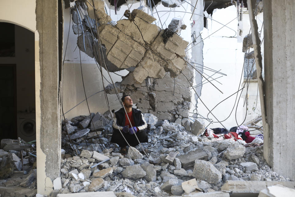 A Palestinian looks at the destruction after an Israeli strike on a residential building in Rafah, Gaza Strip, Wednesday, Feb. 21, 2024. AP Photo/Hatem Ali)