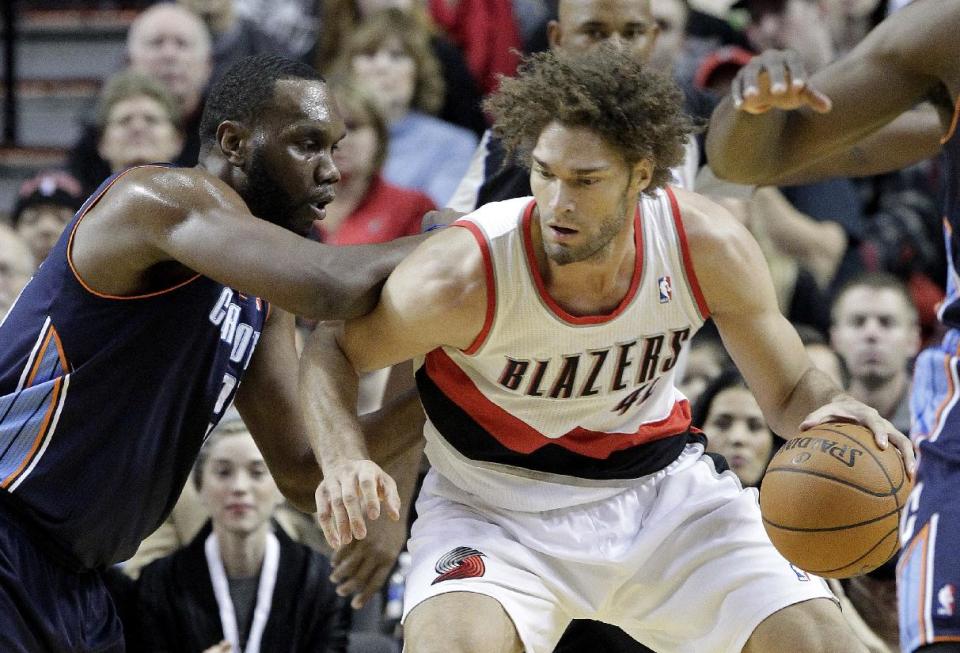 Portland Trails Blazers center Robin Lopez, right, works the ball in against Charlotte Bobcats center Al Jefferson during the first half of an NBA basketball game in Portland, Ore., Thursday, Jan. 2, 2014. (AP Photo/Don Ryan)