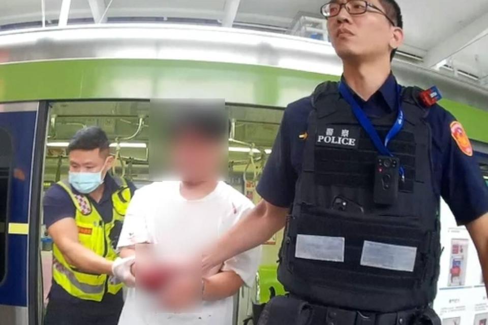 捷運警察將洪嫌押走，今天他坦承為之支持廢死而作案。（警方提供）