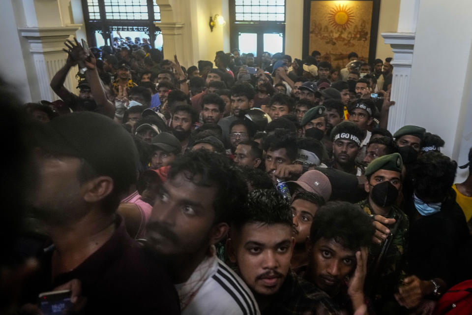 FILE - Protesters storm the office building of Prime Minister Ranil Wickremesinghe, demanding he resign after President Gotabaya Rajapaksa fled the country an amid economic crisis in Colombo, Sri Lanka, July 13, 2022. Rioters poured into the streets, setting homes of government ministers aflame and storming the presidential palace, sending the leader tied to onerous deals with China fleeing the country. (AP Photo/Rafiq Maqbool, File)