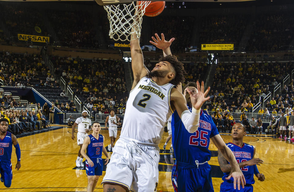 Michigan forward Isaiah Livers (2) attempts a dunk ahead of Presbyterian guard JC Younger (25) in the first half of an NCAA college basketball game at Crisler Center in Ann Arbor, Mich., Saturday, Dec. 21, 2019. (AP Photo/Tony Ding)