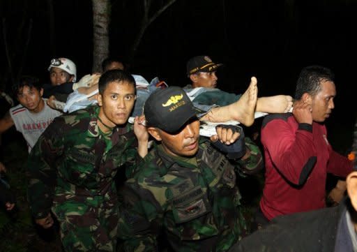 A rescue team evacuates a survivor of a helicopter crash at Dua Sudara mountain in Bitung, North Sulawesi. 10 people, including at least two Australians employed by Melbourne-based Newcrest Mining, were killed in the crash officials said Thursday