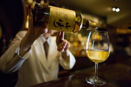 A bartender pours Yamazaki whisky at the Hibiya whisky bar in the Ginza district in Tokyo December 2, 2014. REUTERS/Thomas Peter