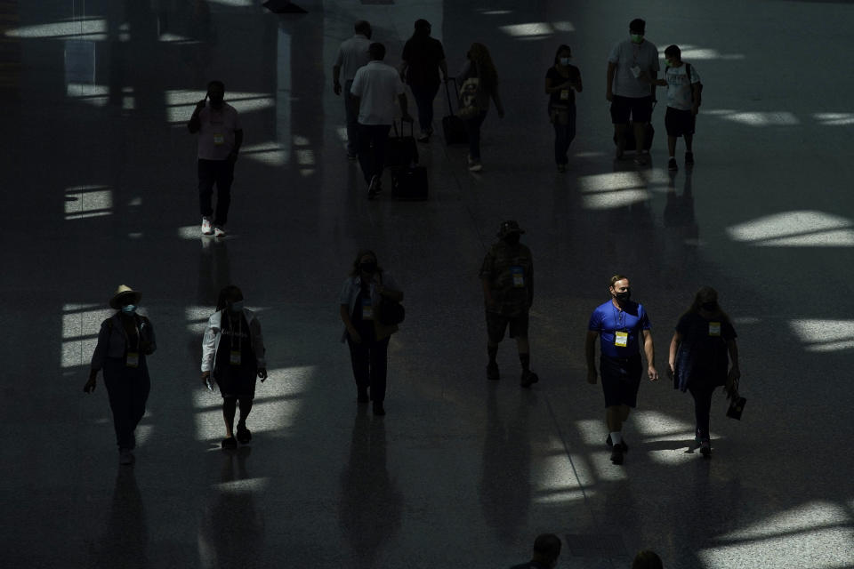 People walk through the Las Vegas Convention Center on final day of the the ASD Market Week convention Wednesday, Aug. 25, 2021, in Las Vegas. In pre-COVID times, business events like conferences and trade shows routinely attracted more than 1 billion participants and $1 trillion in direct spending each year. The pandemic brought those gatherings to a sudden halt, and now in-person meetings are on the rebound from Las Vegas to Beijing. (AP Photo/John Locher)