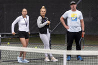 Yuliya Shupenia, left, Iris Harris, center, and coach Chris Tontz watch players on a practice court at the Charleston Open tennis tournament in Charleston, S.C., Monday, April 3, 2023. Yuliya Shupenia and Iris Beatrice Harris are participants in the women’s professional tennis tour’s Coaching Inclusion Program to develop female coaches. (AP Photo/Mic Smith)