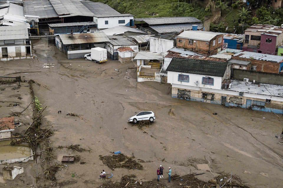 A car sits in a flooded street in Las Tejerias, Venezuela, Sunday, Oct. 9, 2022. Days of heavy rains overflowed Las Tejerias river and caused flash floods. (AP Photo/Matias Delacroix)