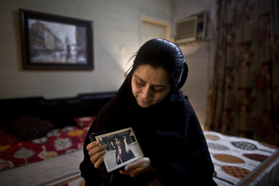 In this Wednesday, March 12, 2014 photo, Pakistani Amber Tariq, 55, mother of lawyer Fizza Malik, 23, who was one of eleven victims killed by suicide bombers in an attack on a court complex on March 3, 2014, looks at her daughter's photograph in her bedroom, at their home on the outskirts of Islamabad, Pakistan. "Fizza was a very confident, intelligent, talented, and a loving daughter," Amber said. (AP Photo/Muhammed Muheisen)