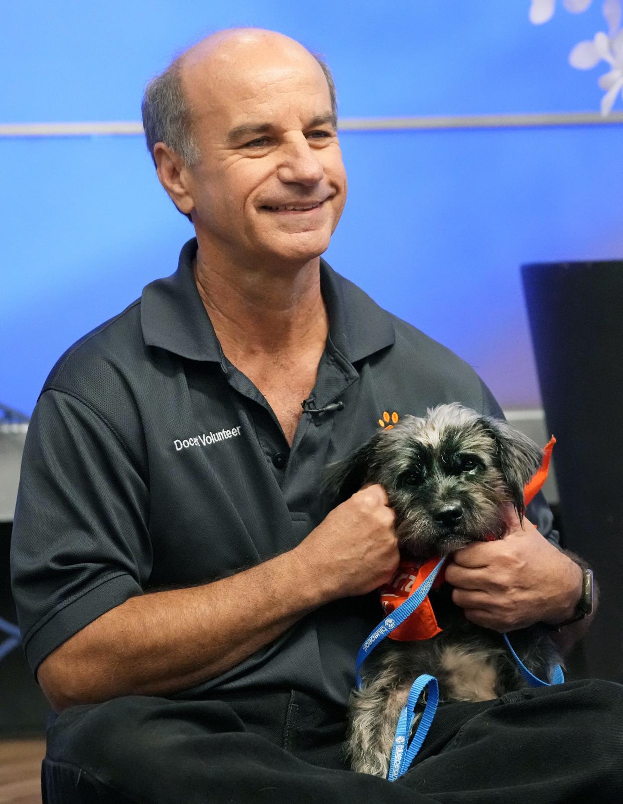 Arizona Humane Society volunteer Perry Fanzo introduces Minka, who is available for adoption, during the Pets of Parade show on Jan. 12, 2023, in Phoenix. Fanzo has been a volunteer with the Arizona Humane Society for 21 years and recently received the Lifetime Achievement President's Volunteer Service Award.