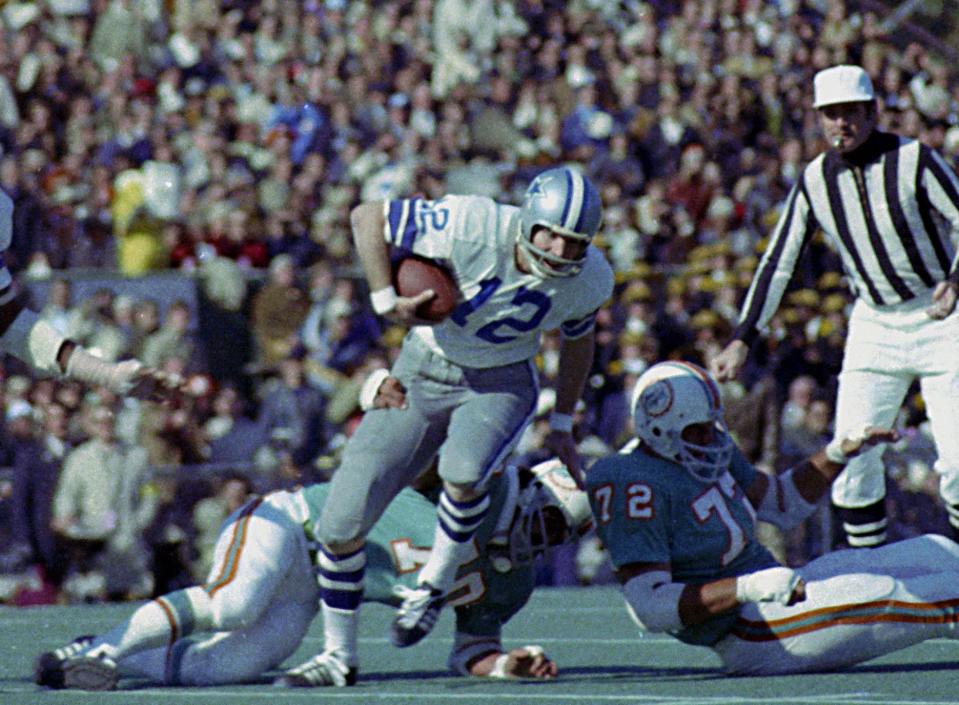 FILE - In this Jan. 16, 1972, file photo, Dallas Cowboys quarterback Roger Staubach (12) tries to escape the grasp of Miami Dolphins defender Jim Riley (70) during Super Bowl VI in New Orleans, La. Staubach, voted the game's most valuable player, completed 12 of 19 passes for 119 yards and two TDs.