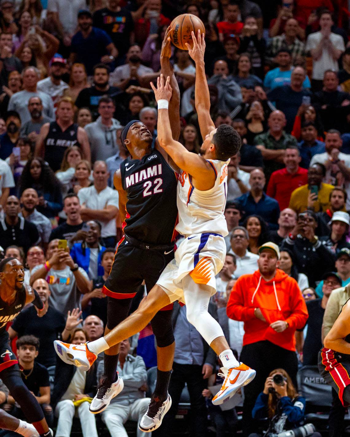 Miami Heat forward Jimmy Butler (22) gets the game winning block on Phoenix Suns guard Devin Booker (1) during the second half of an NBA game at FTX Arena in Downtown Miami, Florida, on Monday, November 14, 2022. The Heat defeated the Suns 113-112.