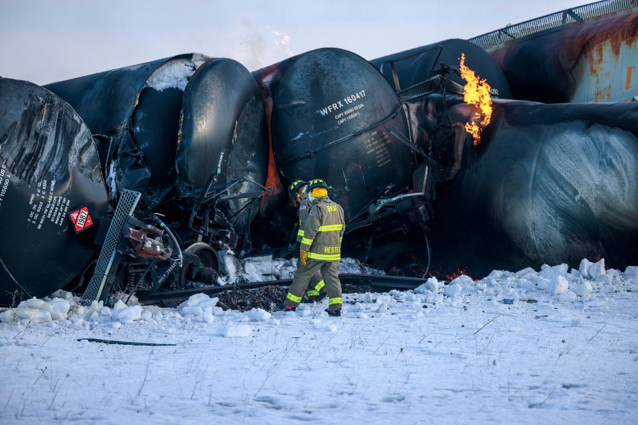 Firefighters work near piled-up train cars, near Raymond, Minnesota on Thursday, March 30, 2023, the morning after a BNSF freight train derailed (AP)