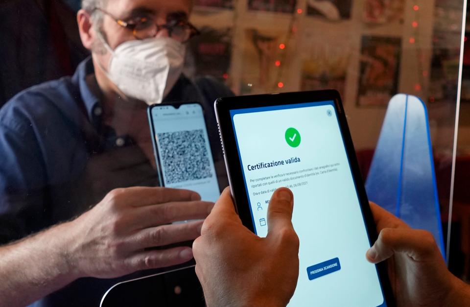 A customer in Milan, Italy, has his "green pass" checked at the entrance of a cinema.