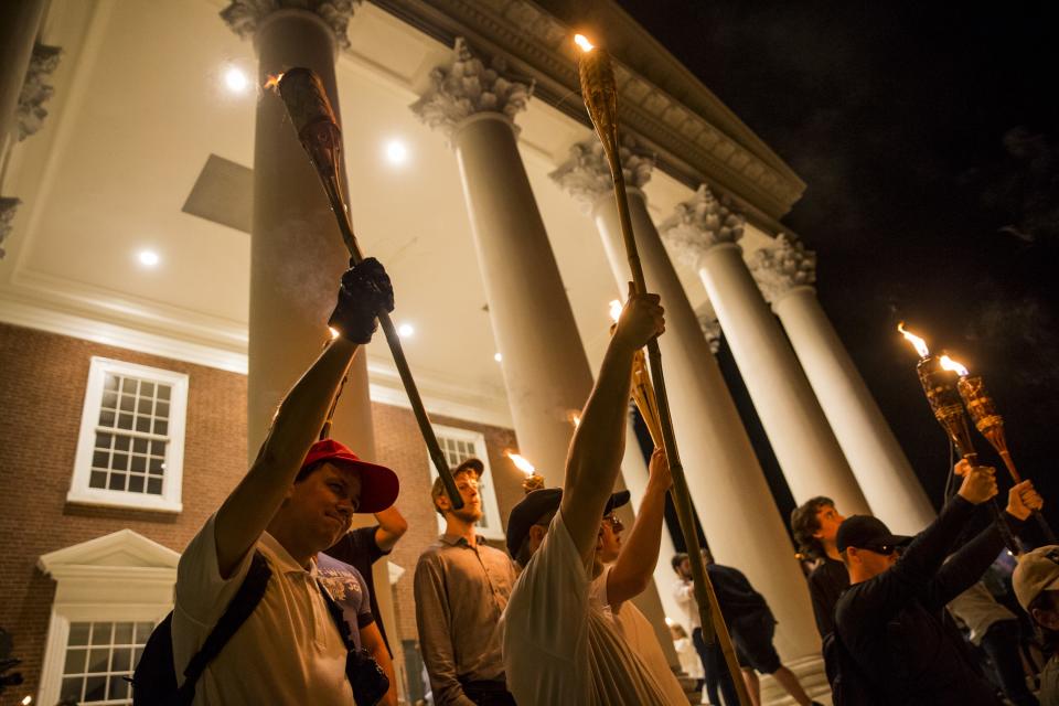 <p>Young men hold up torches on the steps of the Rotunda as other Neo Nazis, Alt-Right, and White Supremacists march through the University of Virginia Campus with torches in Charlottesville, Va., on Aug. 11, 2017. (Photo: Samuel Corum/Anadolu Agency/Getty Images) </p>