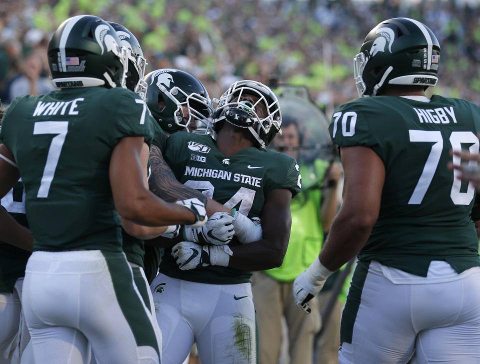 Michigan State's Elijah Collins, center, celebrates his rushing touchdown with teammates during the fourth quarter of an NCAA college football game against Arizona State, Saturday, Sept. 14, 2019, in East Lansing, Mich. (AP Photo/Al Goldis)