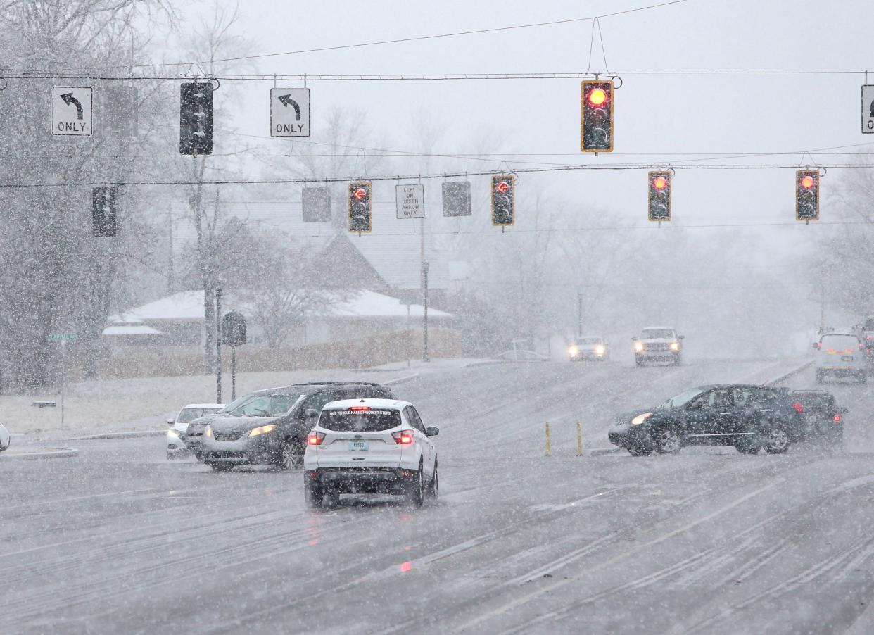 Traffic at Capital Avenue and Lincoln Way East in Mishawaka moves among the large snowflakes Friday afternoon as the late winter storm begins its course dropping rain and wet snow on the area.