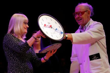 Nobel Laurette Dudley Herschbach (R) presents the 2016 IgNobel Prize in Physics to Susanne Akesson of Sweden for work "discovering why white-haired horses are the most horsefly-proof horses, and for discovering why dragonflies are fatally attracted to black tombstones" during the 26th First Annual Ig Nobel Prize ceremony at Harvard University in Cambridge, Massachusetts, U.S. September 22, 2016. REUTERS/Brian Snyder