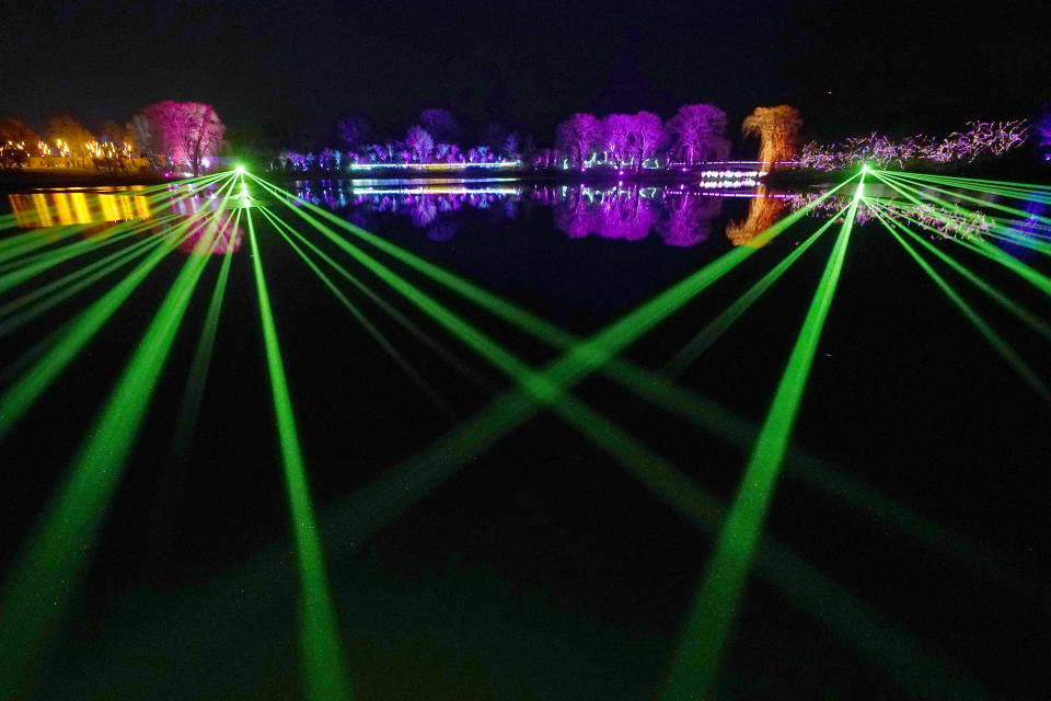 "Laser Lake," a show of multicolored light and music, dances across the Great Basin Thursday, Dec. 14, 2023, as part of the Chicago Botanic Garden's 1.3-mile, fifth annual Lightscape holiday experience of light and music in Glencoe, Ill. (AP Photo/Charles Rex Arbogast)
