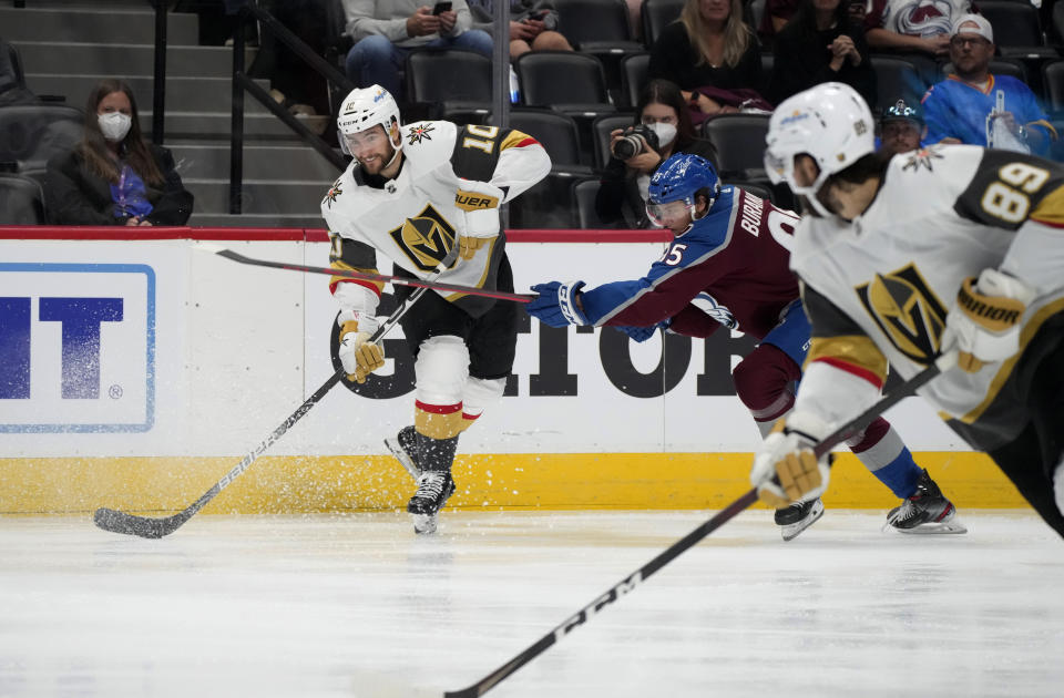 Vegas Golden Knights center Nicolas Roy, left, lifts a pass to right wing Alex Tuch, front, as Colorado Avalanche left wing Andre Burakovsky defends during the third period of Game 5 of an NHL hockey Stanley Cup second-round playoff series Tuesday, June 8, 2021, in Denver. (AP Photo/David Zalubowski)