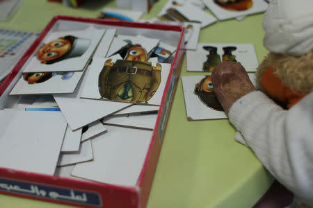 Young girls, severely burnt and maimed by explosions in Yemen, Syria and Iraq, play puzzles as an occupational therapist assesses their cognitive development inside a Medecins Sans Frontieres hospital in Amman, Jordan, November 20, 2016. Picture taken November 20, 2016. Lin Taylor/Thomson Reuters Foundation via REUTERS