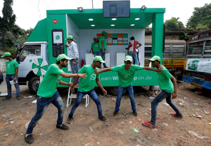 FILE PHOTO: WhatsApp-Reliance Jio representatives perform in a street play during a drive by the two companies to educate users, on the outskirts of Kolkata