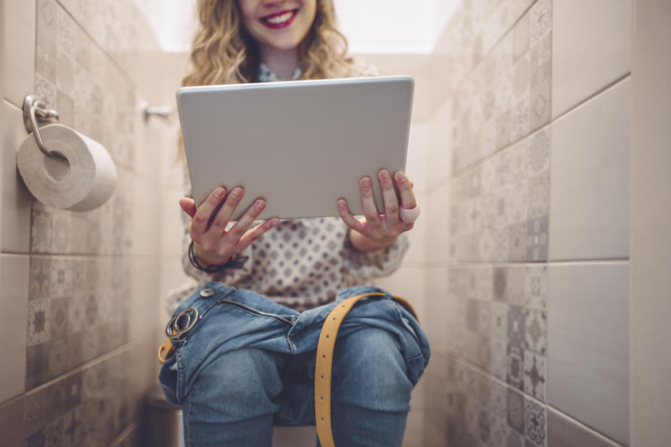 Woman using the loo while in a virtual work meeting. (Getty Images)