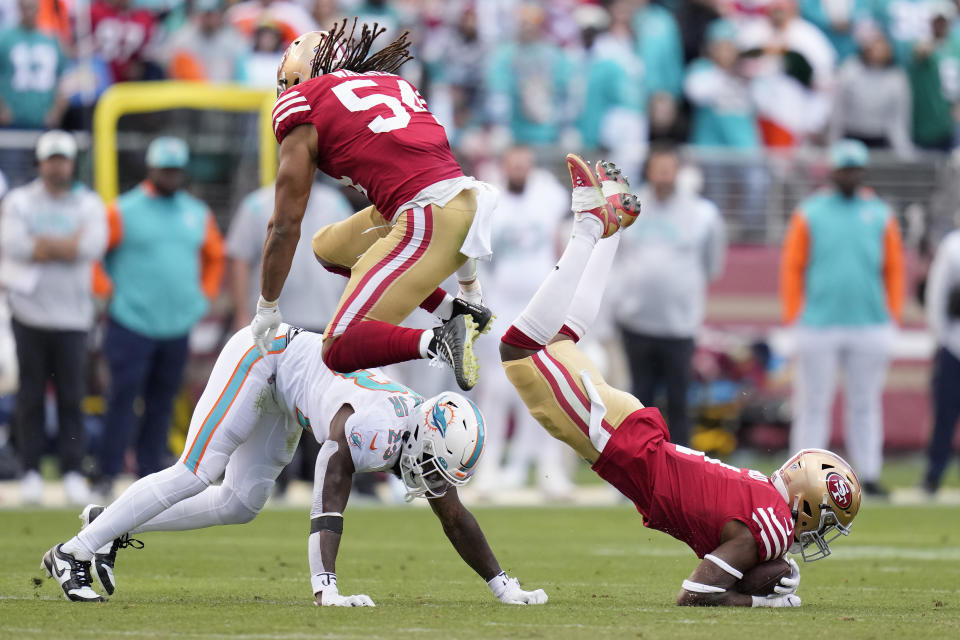 San Francisco 49ers cornerback Jimmie Ward, right, intercepts a pass in front of teammate linebacker Fred Warner (54) and Miami Dolphins running back Jeff Wilson Jr. (23) during the second half of an NFL football game in Santa Clara, Calif., Sunday, Dec. 4, 2022. (AP Photo/Godofredo A. Vásquez)