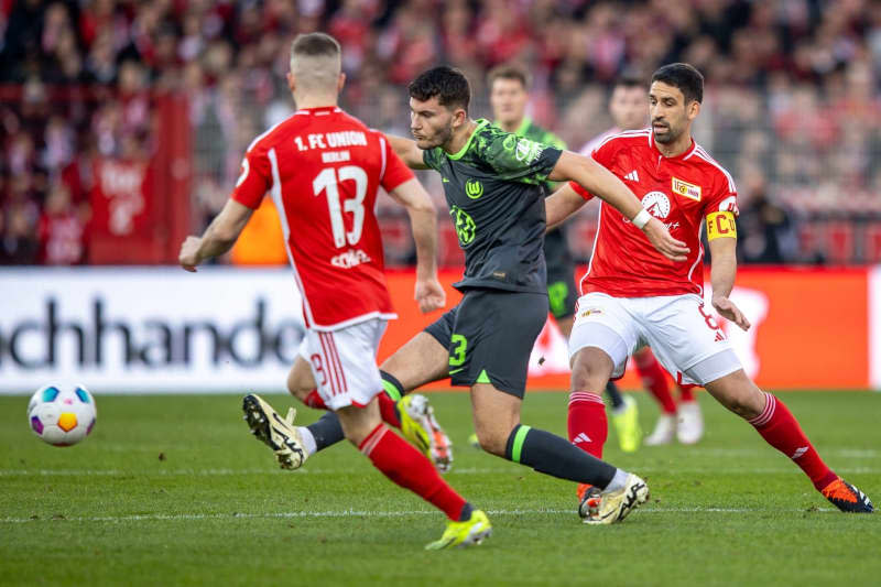 VfL Wolfsburg's Sebastiaan Bornauw (L) fights for the ball against Berlin's Rani Khedira during the German Bundesliga soccer match between FC Union Berlin and VfL Wolfsburg at An der Alten Foersterei. Andreas Gora/dpa