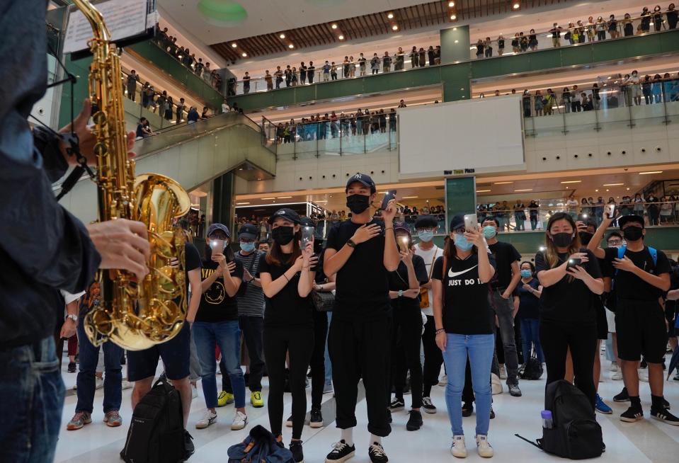 Protestors wearing masks in defiance of a recently imposed ban on face coverings perform at a shopping mall in Hong Kong, Sunday, Oct.13, 2019. The semi-autonomous Chinese city is in its fifth month of a movement that initially began in response to a now-withdrawn extradition bill that would have allowed Hong Kong residents to be tried for crimes in mainland China. The protests have since ballooned to encompass broader demands for electoral reforms and an inquiry into alleged police abuse. (AP Photo/Vincent Yu)