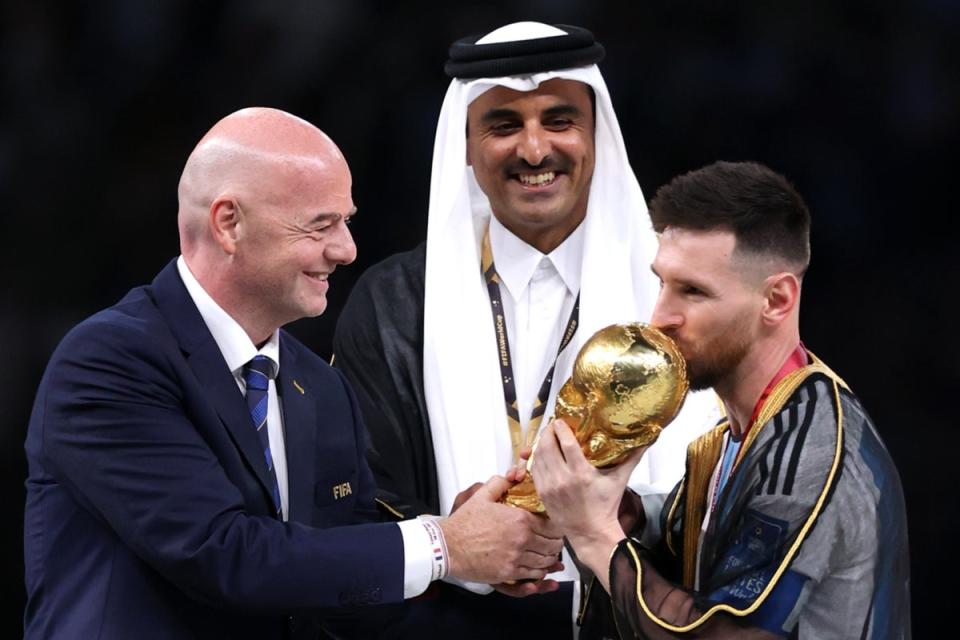 Gianni Infantino, president of Fifa, hands the Fifa World Cup 2022 winner's trophy to Lionel Messi of Argentina at Lusail Stadium on December 18, 2022 in Lusail City, Qatar (Julian Finney/Getty Images)