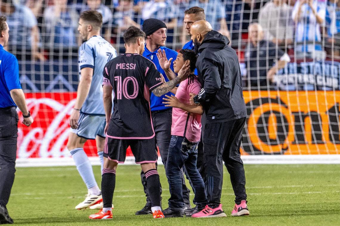 A young Inter Miami fan makes it onto the field to take a photo with forward Lionel Messi (10) during an MLS game against Sporting Kansas City at GEHA Field at Arrowhead Stadium on Saturday, April 13, 2024, in Kansas City.