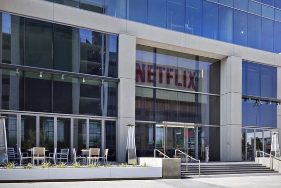 The glass front face of a building with the Netflix logo above the door.