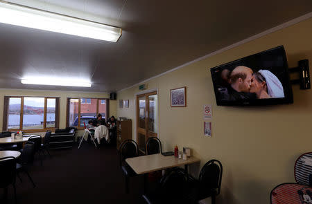 The royal wedding of Britain's Prince Harry and Meghan Markle is being broadcasted on TV as people sit in a restaurant in Port Stanley, Falkland Islands, May 19, 2018. REUTERS/Marcos Brindicci