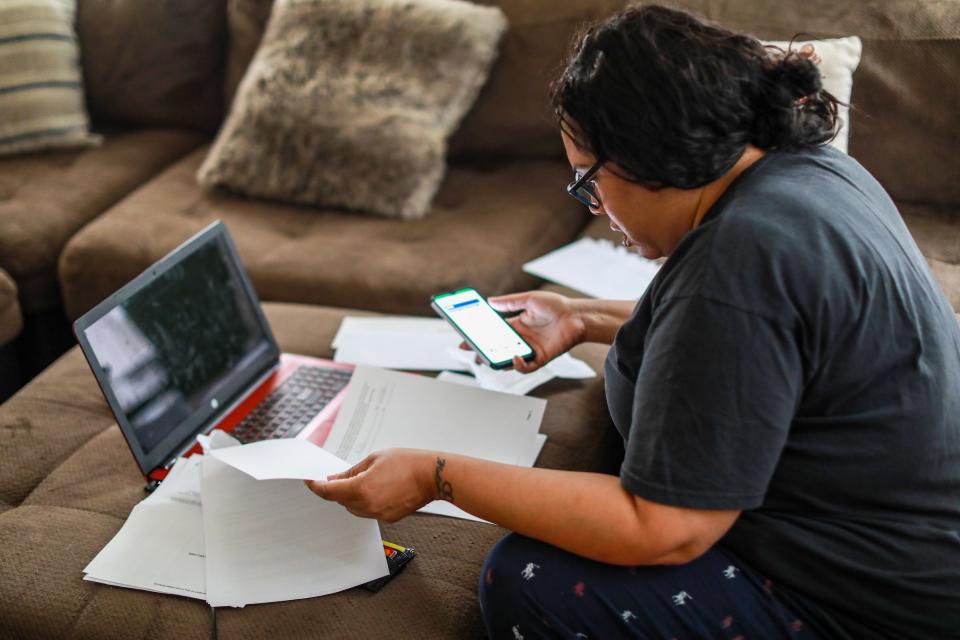 Christanine Brodis, 48, of Detroit talks on the phone with a representative from the Accounting Aid Society to help her file her 2020 taxes at her home on Feb. 13, 2021. Brodis lost her job as a personal home care provider and is struggling to get a tax refund from last year and she did not get one of her stimulus checks.