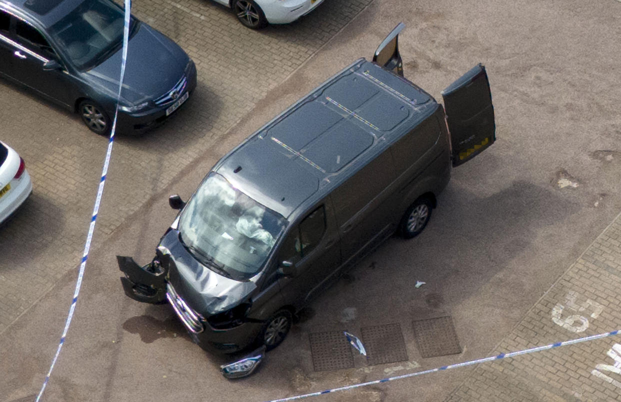 A damaged van is surrounded by a police cordon on Laing Close in Hainault, north east London. (PA)