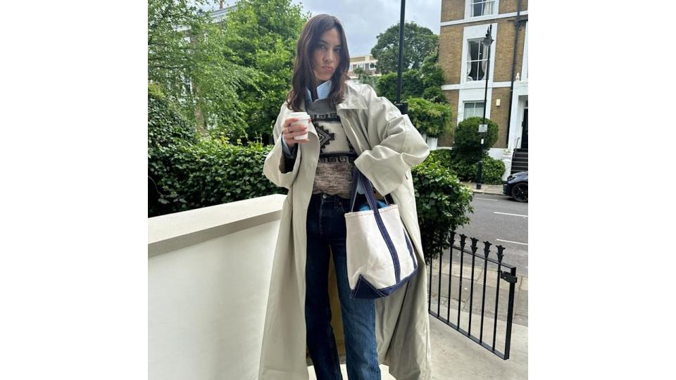 Alexa wears a versatile trench coat over a jumper, shirt and jeans