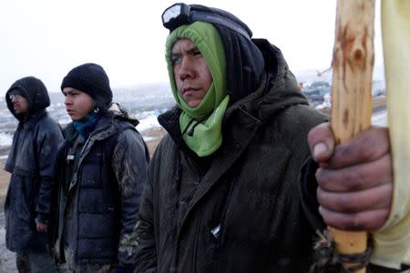 Ezekiel Bahee, 18, of the Navajo Tribe of Arizona, stands with other opponents of the Dakota Access oil pipeline as they prepare to confront police calling for them to evacuate their main camp near Cannon Ball, North Dakota, U.S., February 22, 2017. REUTERS/Terray Sylvester