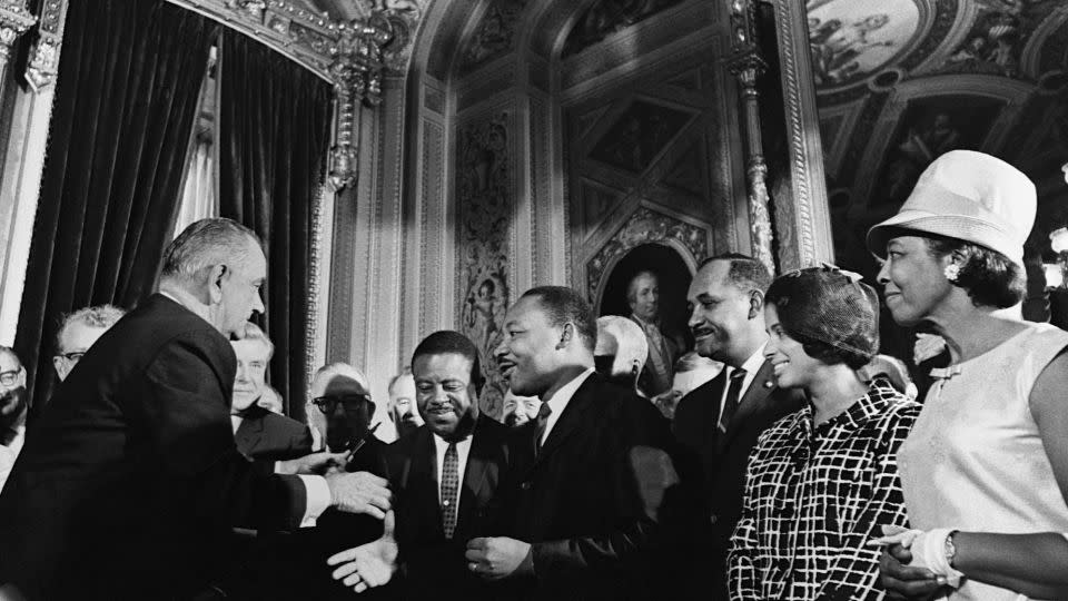 President Lyndon B. Johnson greets civil rights leaders Martin Luther King, Jr., Ralph Abernathy and Clarence Mitchell after signing the voting rights bill in 1965. - Corbis/Getty Images