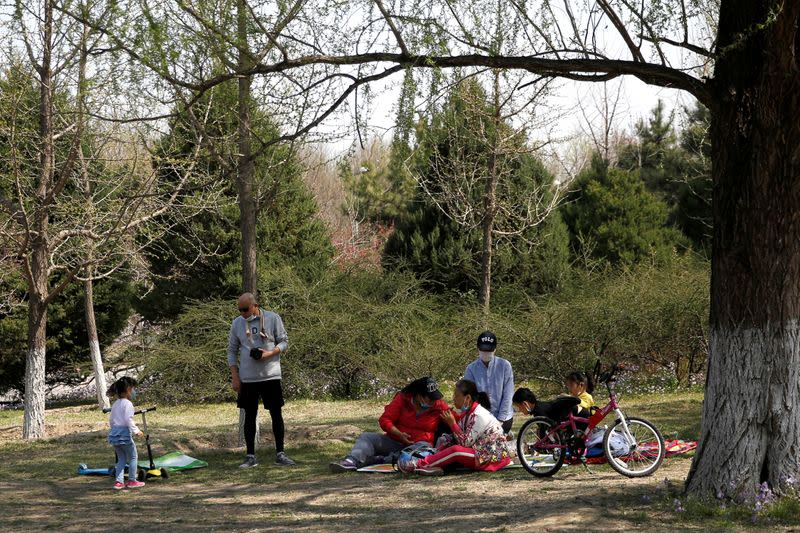 FILE PHOTO: People wearing face masks enjoy a picnic at a park during Chinese Qingming festival holiday in Beijing