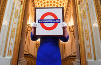 <p>Sally Goodsir, Assistenzkuratorin für ornamentale Kunst des Royal Collection Trust, zeigt eine Buckingham-Palace-Version der Londoner U-Bahn-Tafel, die 2010 bei einem Besuch in der Aldgate East Tube Station übergeben wurde. – Montag, 3. April 2017, Buckingham Palace, London. Eine Auswahl an royalen Geschenken wird ab 22. Juli 2017 im Zuge der Sommer-Öffnung der State Rooms im Buckingham Palace ausgestellt. (Toby Melville/Reuters) </p>