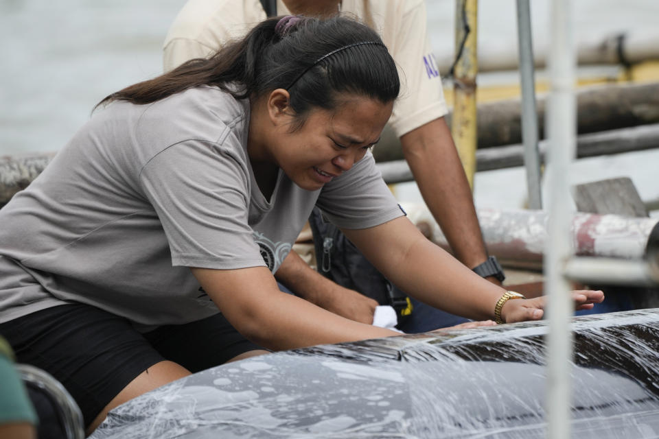 A family member grieves as they transfer the coffin of one of the victims of a passenger boat that capsized in Binangonan, Rizal province, Philippines on Friday, July 28, 2023. A small Philippine ferry turned upside down when passengers suddenly crowded to one side in panic as fierce winds pummeled the wooden vessel, leaving scores of people dead while others were rescued, officials said Friday. (AP Photo/Aaron Favila)